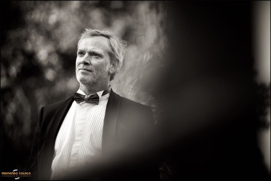 Portrait of the groom, by the wedding photographer, among the foliage of trees at Morada do Sol in Sintra.