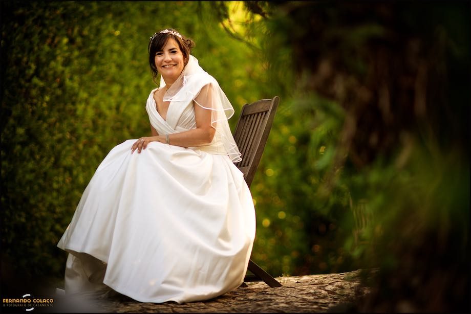 The bride sitting on a wooden chair, in the garden of Morada do Sol in Sintra