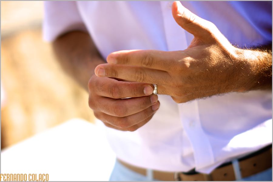 Detail of the groom's hand, caressing the ring just given to him by the bride in Praia Grande, next to Club Nau in Ferragudo.