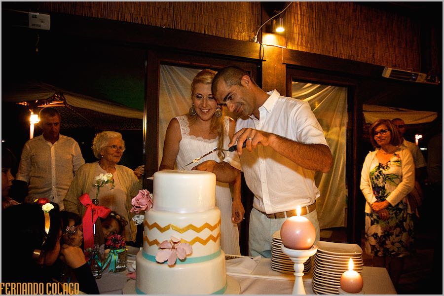 The bride and groom cut their wedding cake at the party at Club Nau in Ferragudo.