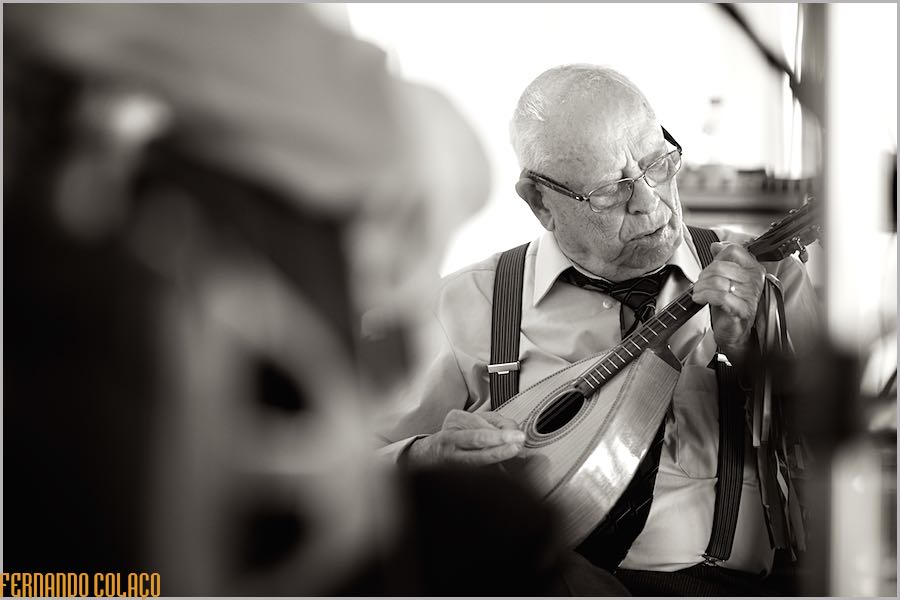 The groom's grandfather playing the mandolin to entertain the guests before the wedding meal.