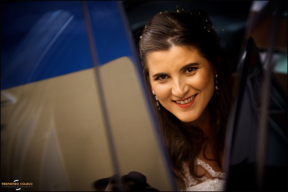 Bride looks at the wedding photographer as she gets out of the car for her wedding ceremony.