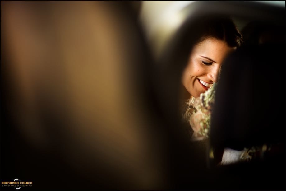 Face of the smiling bride already in the car.