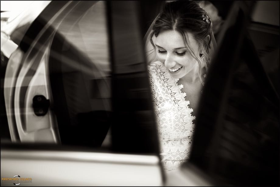 The bride seems to pull her dress into the car that will take her to the wedding ceremony.