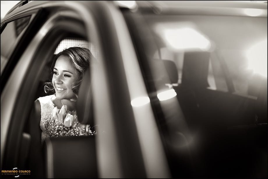 Big smile from the bride as she arrives at the church for the wedding ceremony in the car, viewed by the wedding photographer.