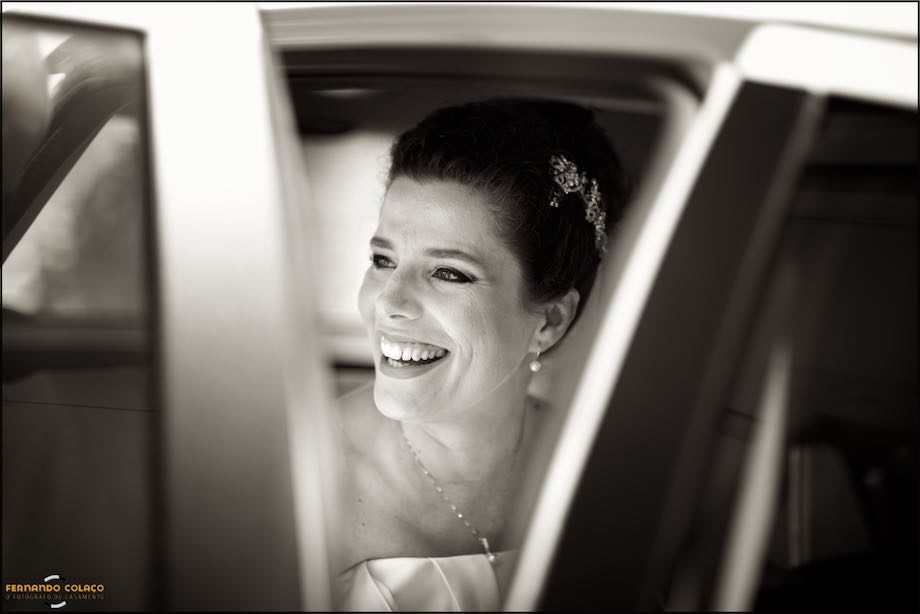 Bride in open laughter, seen through the car doors.
