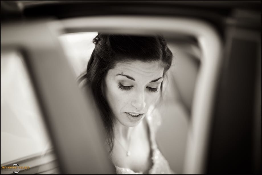 Inside the car, the bride looks down.