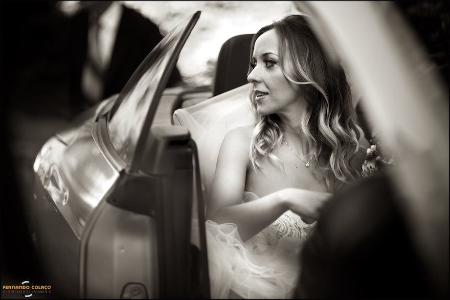 Having just got into the car, the bride looks out.