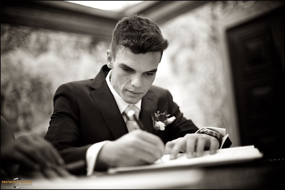 O noivo, muito atento, assina os documentos da cerimonia do casamento na Igreja Paroquial de Nossa Senhora da Assunção em Cascais.