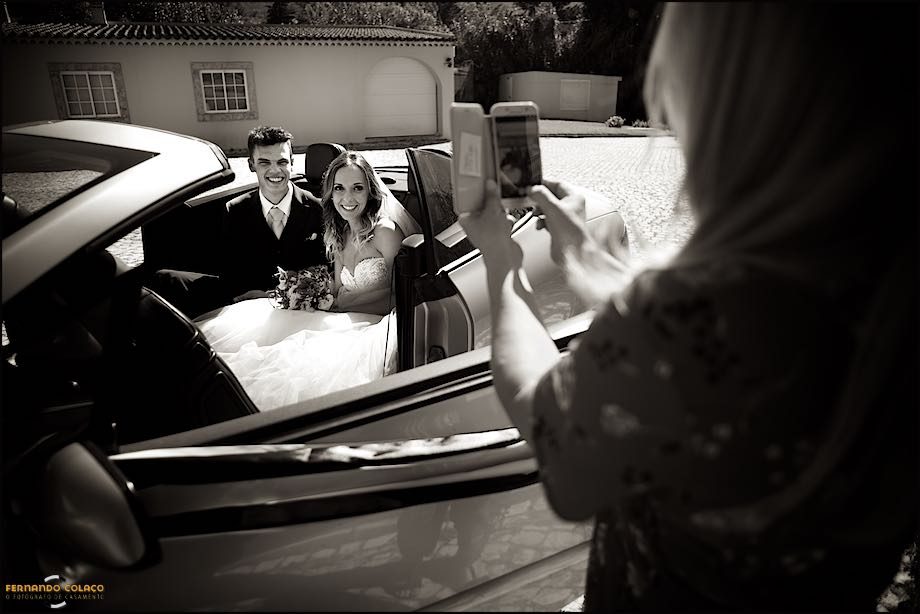 Na chegada à Quinta das Palmeiras em Sintra, os noivos, dentro do automóvel, são fotografados por uma convida do casamento.