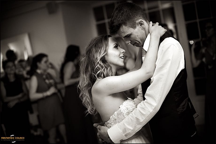 Durante a dança da abertura do baile, o casal recém casado olha um para o outro, com ar feliz.