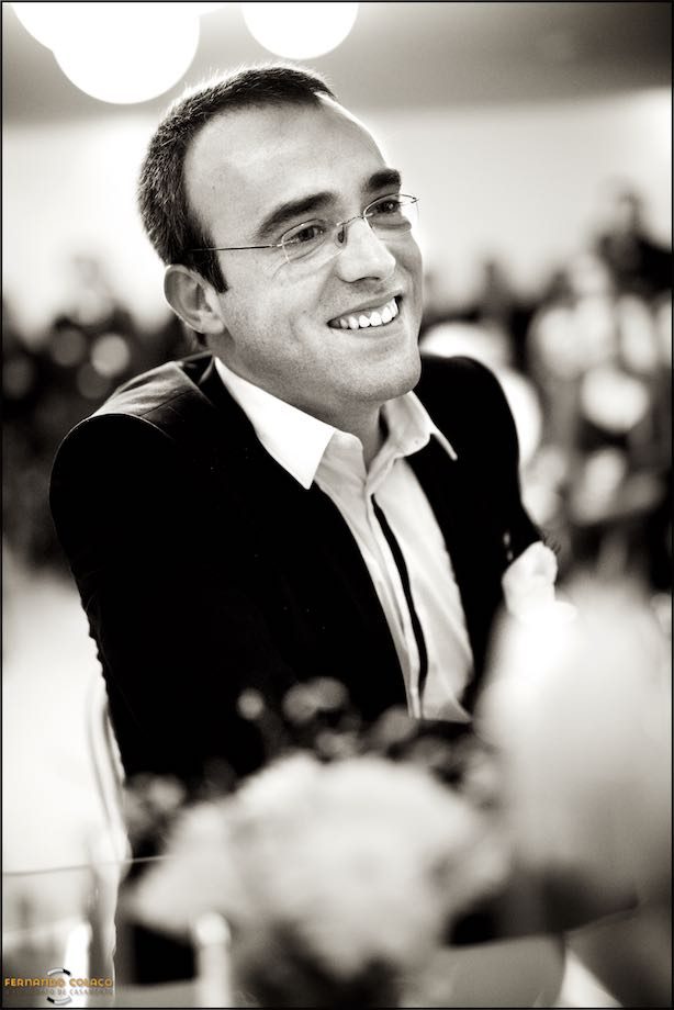 O noivo sorrindo de felicidade, durante a cerimónia do casamento.