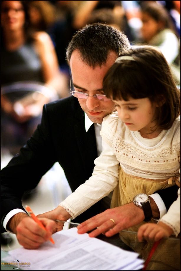 O noivo assina os documentos do casamento, com a sua filha mais velha ao lado.