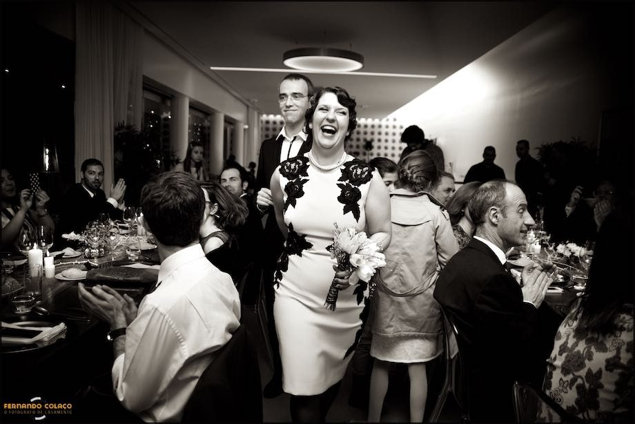 A noiva rindo de satisfação, em frente do noivo no caminha para a mesa da refeição do casamento no Montes Claros - Lisbon Secret Spot.