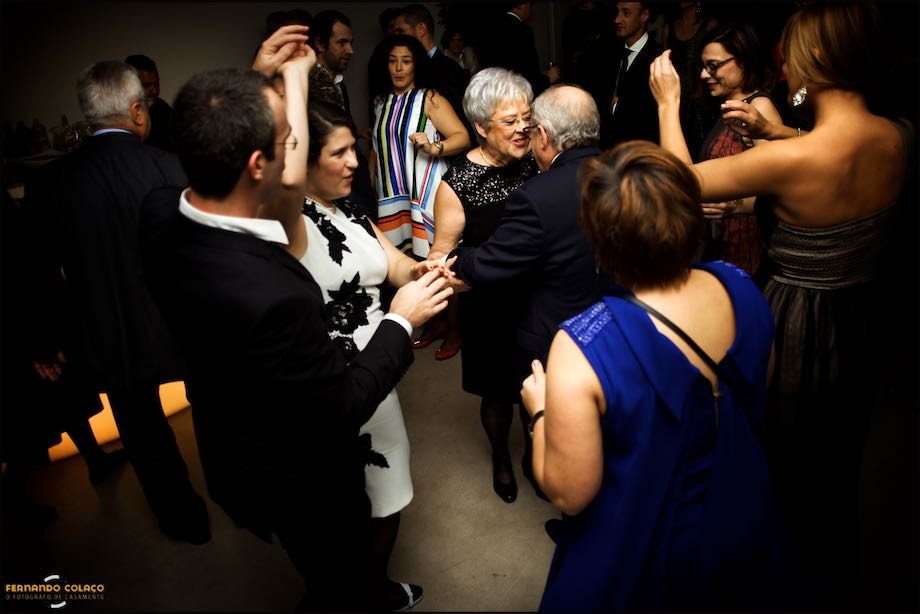 Os pais da noiva dançam, durante a festa do casamento, com os outros convidados fazendo uma roda à sua volta.
