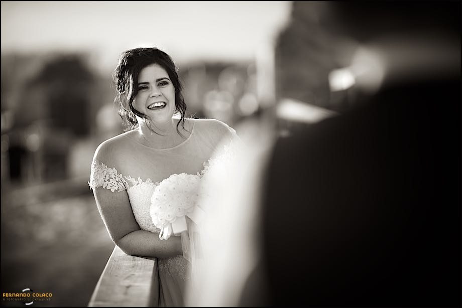 The bride laughing to her baby, on her father's lap, during the session with the wedding photographer.
