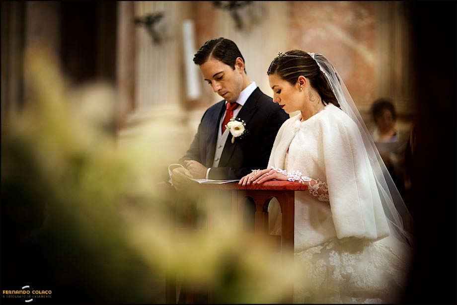 The bride and groom in spiritual recollection, after the wedding rings ceremony in the Basilica of Mafra.