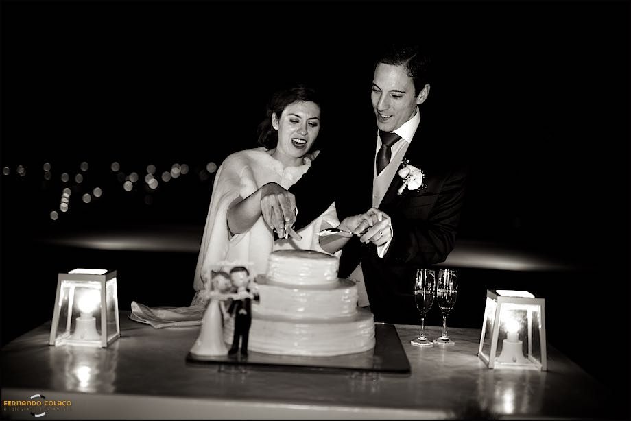 The newly married couple as they cut the wedding cake, in the garden of Casa de Reguengos, in front of their guests.