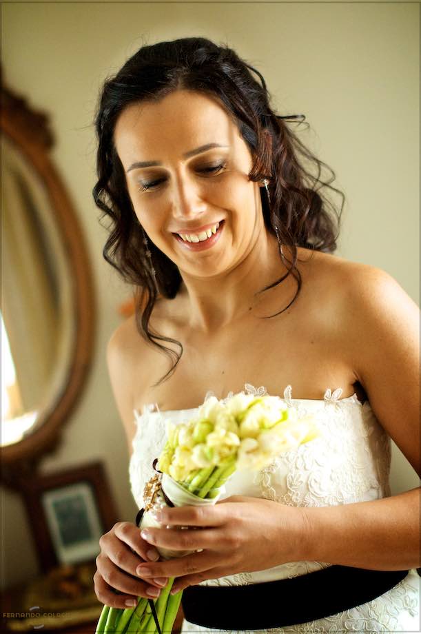 Looking at the bouquet in her hands, the bride smiles.