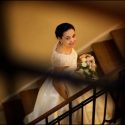 The golden light from the lamps of Palacio Estoril Golf & Wellness Hotel illuminates the bride, walking up the stairs, captured by the wedding photographer in Portugal.