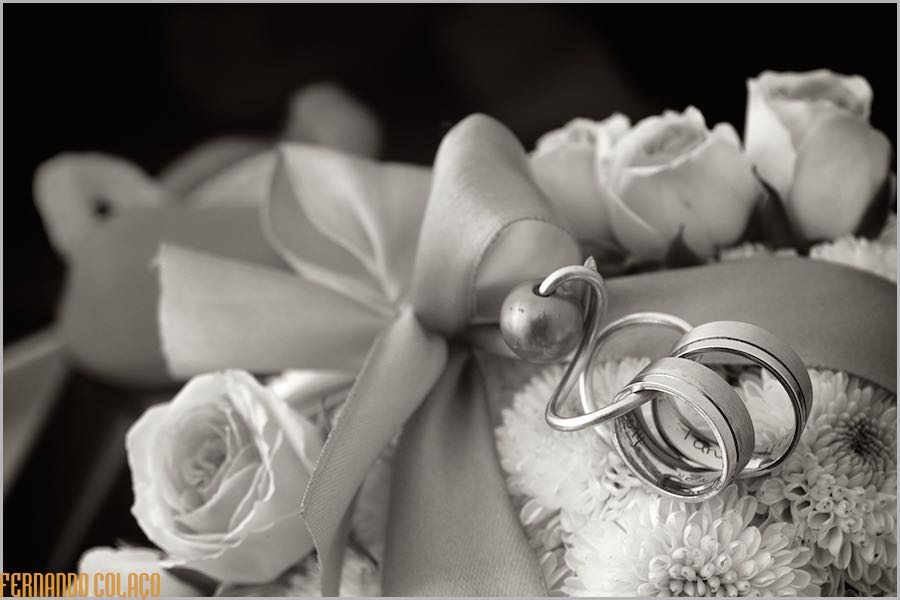 As alianças do casamento numa arranjo floral de rosas e margaridas.