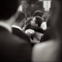Noiva, no meio de convidados, sendo abraça por uma amiga, pelo fotógrafo de casamento em Cascais.