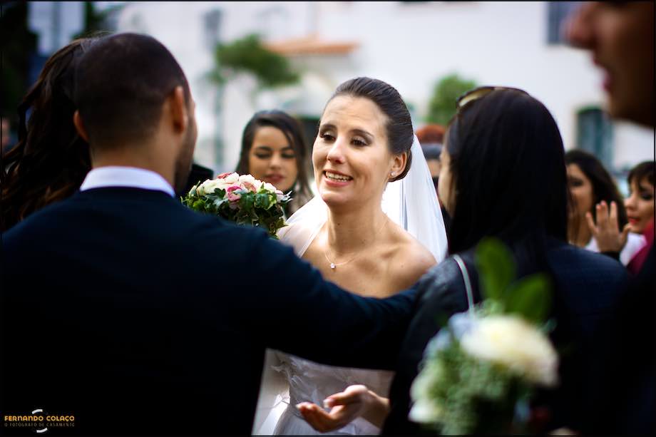 A noiva recebe os cumprimentos de convidados do casamento, em frente da igreja.
