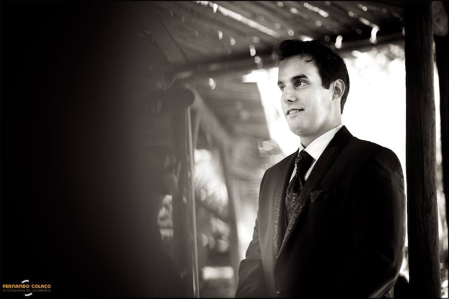 O noivo, sorrindo já no local da cerimónia, espera pela chegada da noiva.