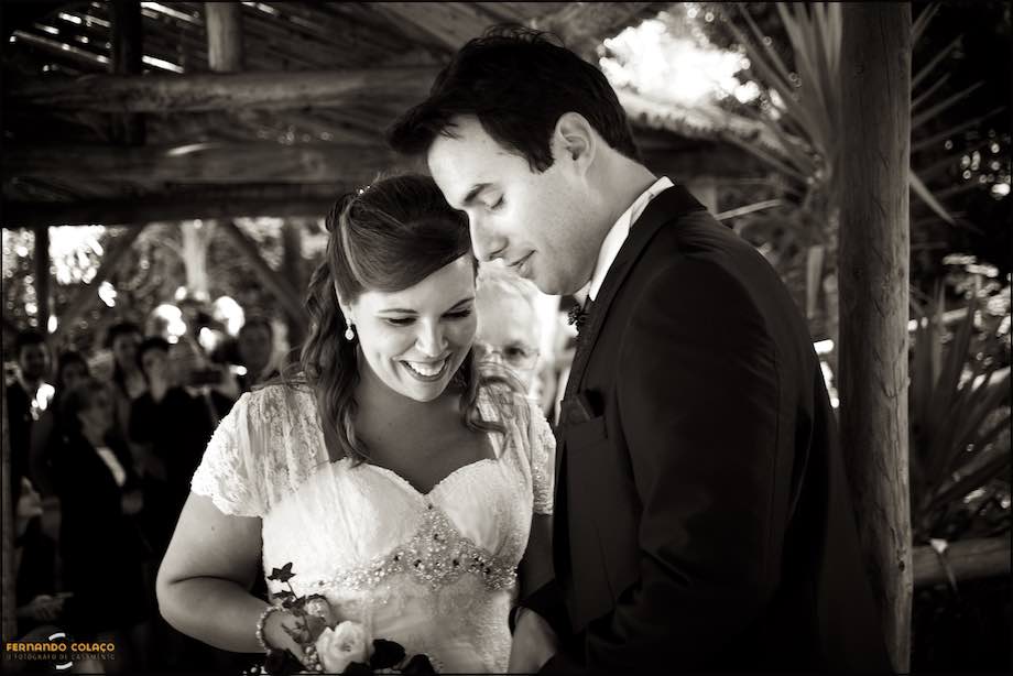 Os noivos sorrindo quando a noiva chega à mesa cerimonial.