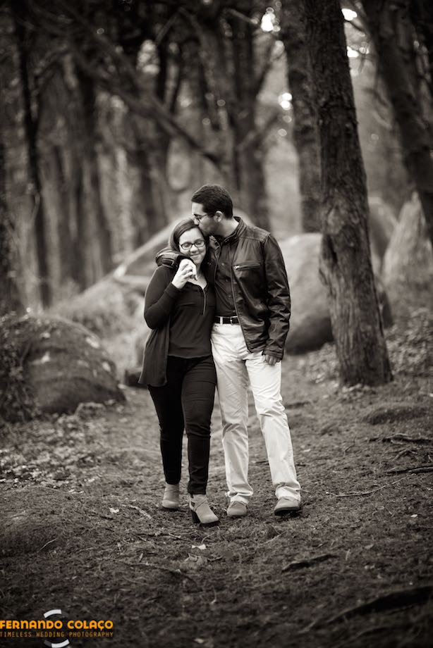Noivo, na sessão de pré casamento, beija a noiva enquanto passeiam pelo bosque da Peninha, em Sintra.
