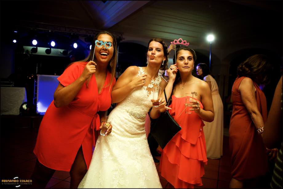 Noiva e duas amigas a brincar com máscaras.