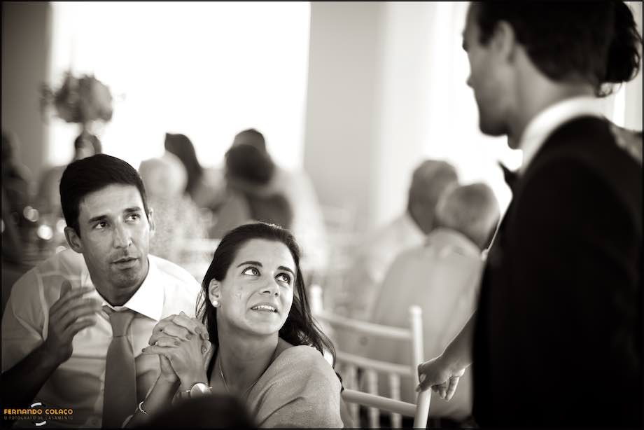 Casal de convidados do casamento conversam com outro convidado.