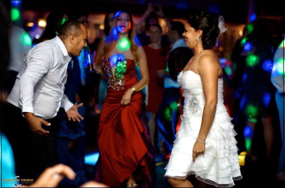 Noiva em frente a convidado do casamento dançando.