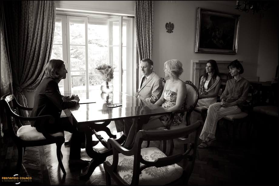 Noivos na mesa da cerimónia do casamento com oficiante.