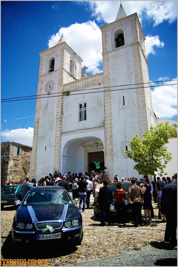 A igreja, onde decorreu a cerimónia do casamento, com todos os presentes, junto da porta principal, saudando os noivos.