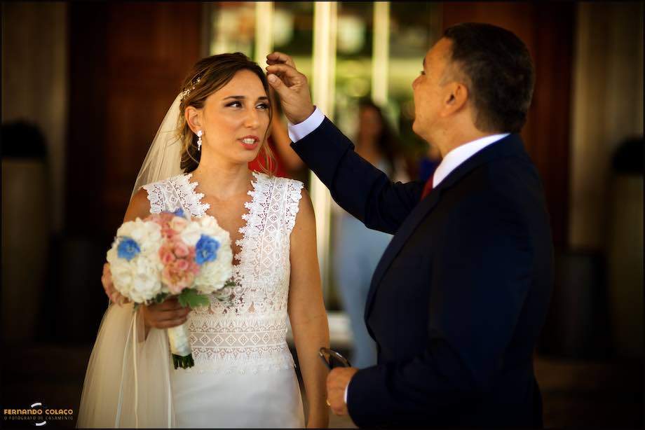 O pai da noiva acerta-lhe uma ponta do cabelo.