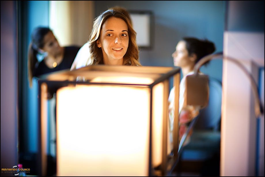 Head of the bride behind a lamp in the preparation for the ceremony, by the wedding photographer in Cascais.