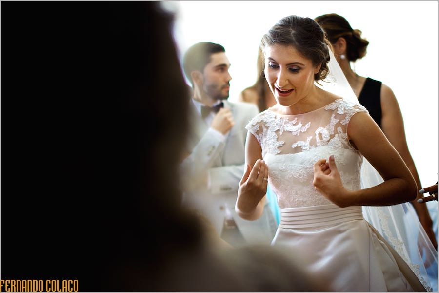 A noiva em conversa com alguém, já pronta para a cerimónia, captada pelo fotógrafo de casamento, num momento em que parece um passo de dança.