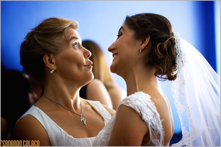 A noiva de frente para a sua mãe e fazendo gestos faciais numa brincadeira de felicidade, captadas pelo fotógrafo de casamento.