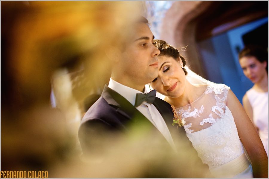 Na cerimónia do casamento a noiva encosta a cabeça ao ombro do noivo com um rosto de felicidade, satisfação e emoção.