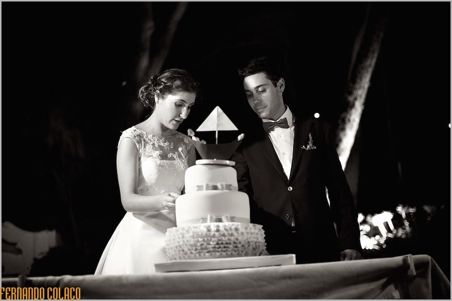 O noivo e a noiva cortando o bolo do casamento no fim da sua festa de casamento na Quinta do Lumarinho.
