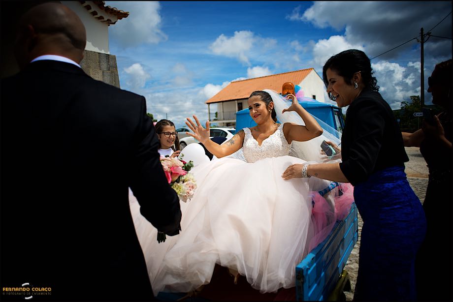 Bride seated in the cargo place of a moto bike.