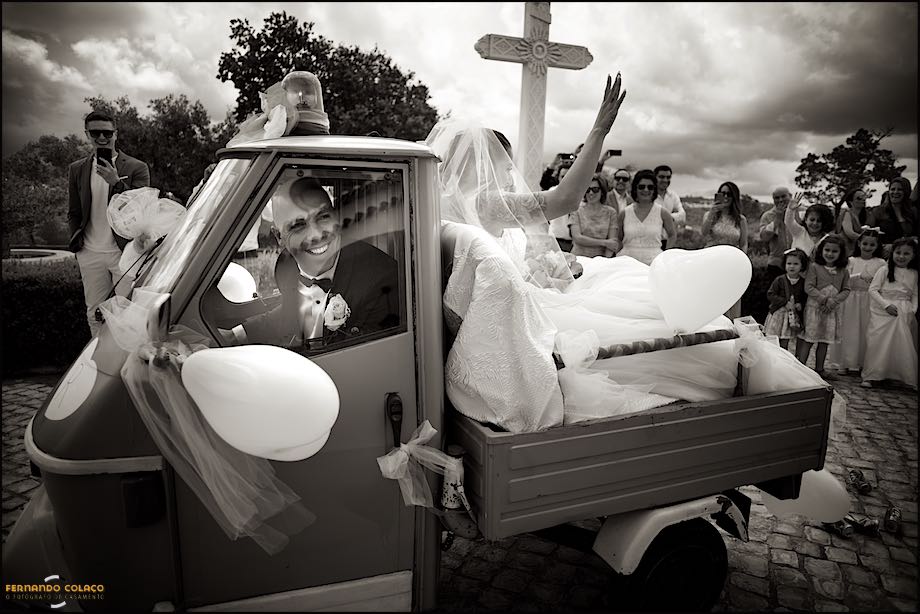 Noivo conduz uma moto de carga com a noiva sentada na traseira até à Quinta da Ramila, vistos pelo fotógrafo de casamento em Leiria.