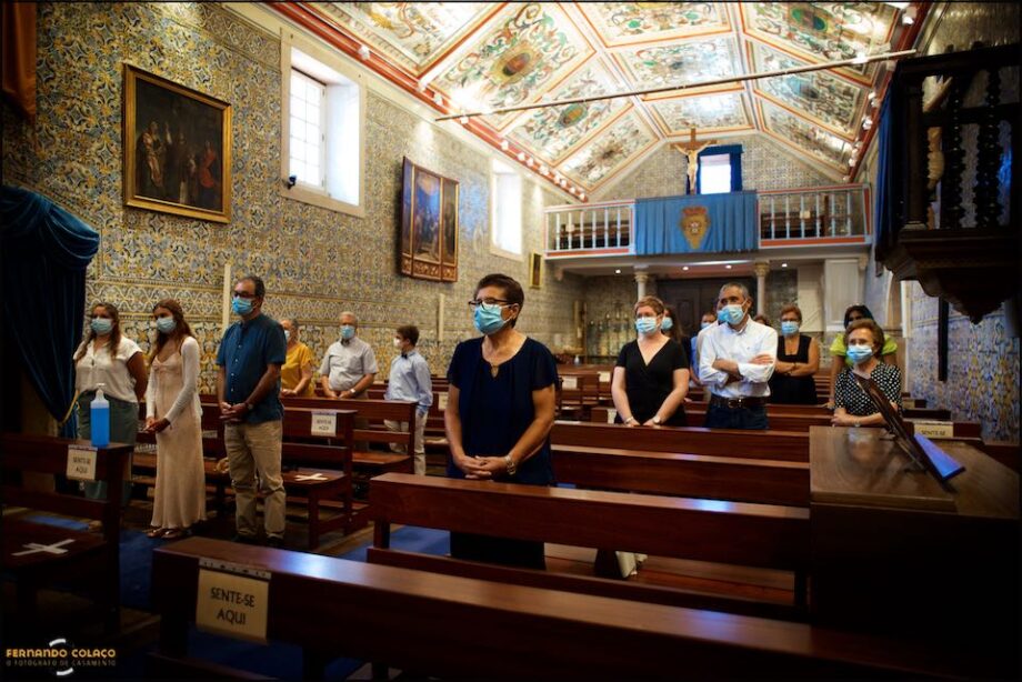 In the church, during the christening ceremony, the girl's family members, few, standing and separated from each other, with anti-Covid 19 masks on their faces.
