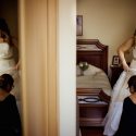 Com imagem duplicada num espelho, a noiva com a sua mãe nos acertos finais do vestir do vestido de noiva vistas pelo fotógrafo de casamento em Lisboa.