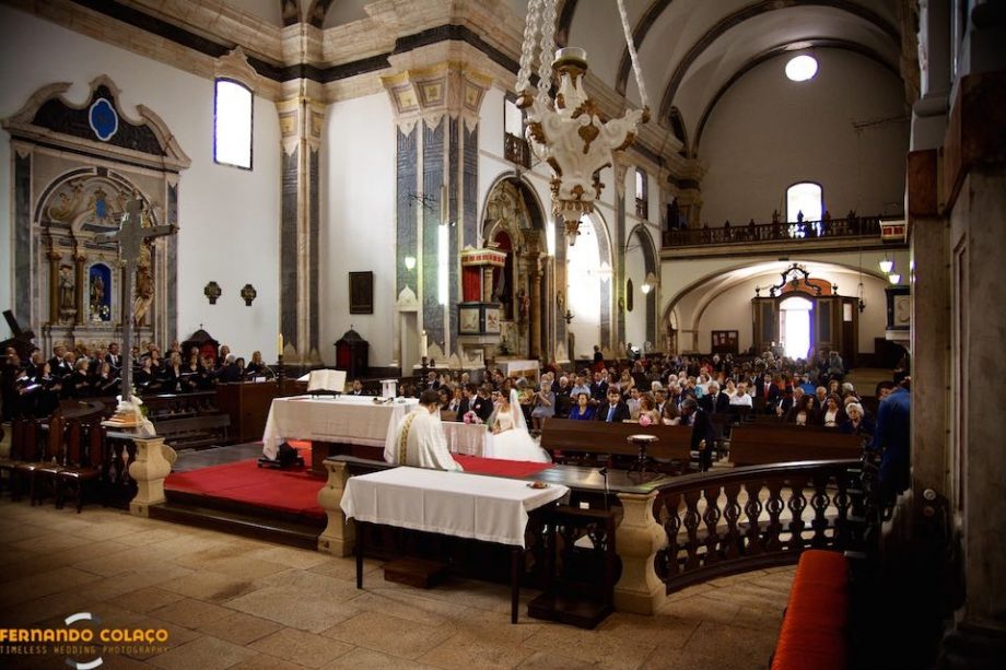 Interior da igreja Matriz de Santa Maria da Devesa em Castelo de Vide,  com os noivos, o padre  e todos os convidados durante a cerimónia do casamento.