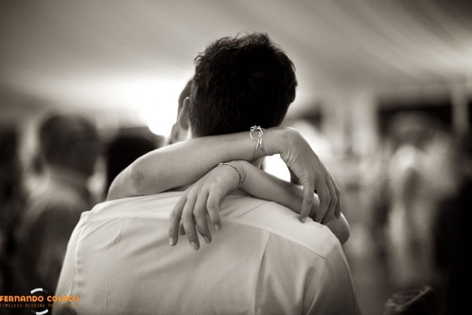 Braços abraçando o pescoço, durante uma dança na festa de casamento, na Quinta da Serra em Sintra, pelo fotógrafo de casamento.