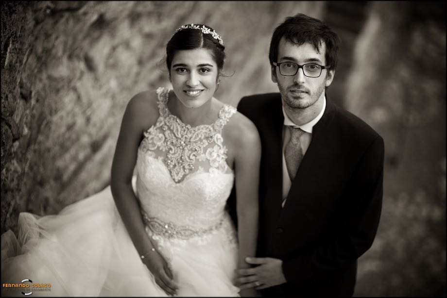The couple in session with the wedding photographer, looks at him, in a portrait.