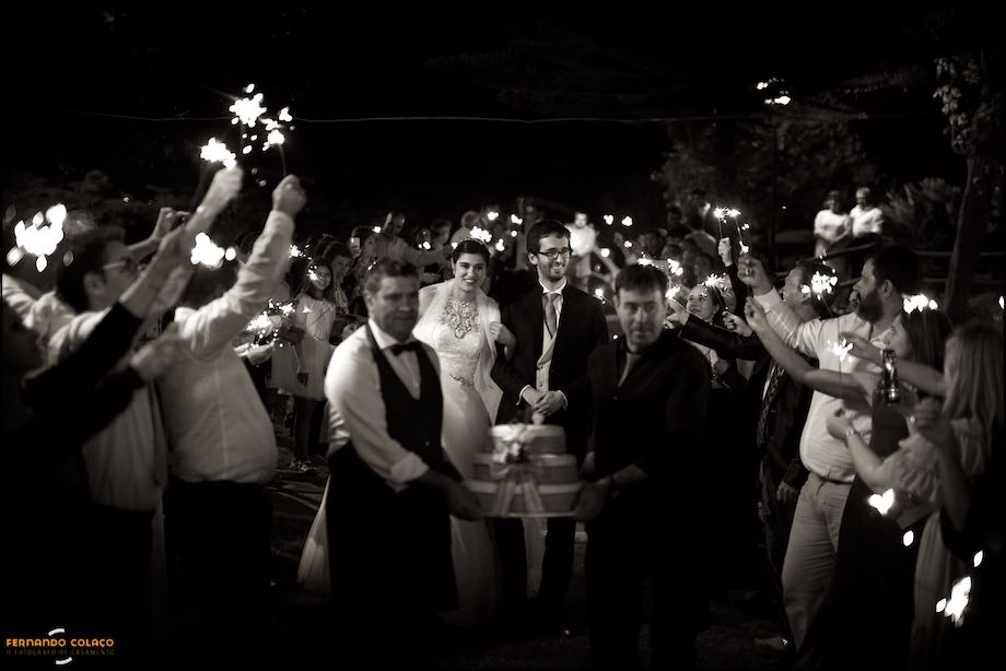 With the cake in front, the bride and groom walk among the guests waving lights.