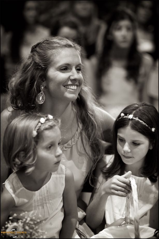 Mother of two girls with them in her arms during the wedding ceremony.